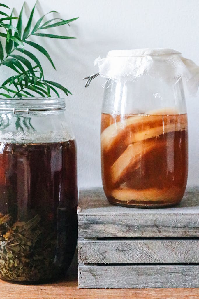 Jars with kombucha and dark herbal beverage