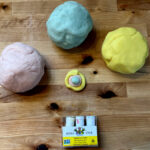 homemade playdough sitting on a countertop with food coloring