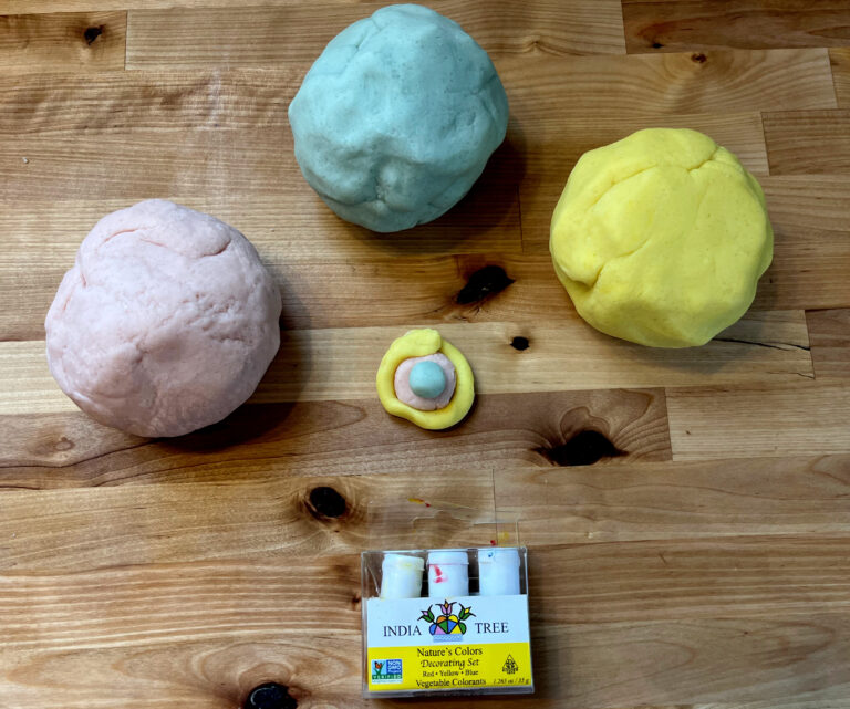 homemade playdough sitting on a countertop with food coloring
