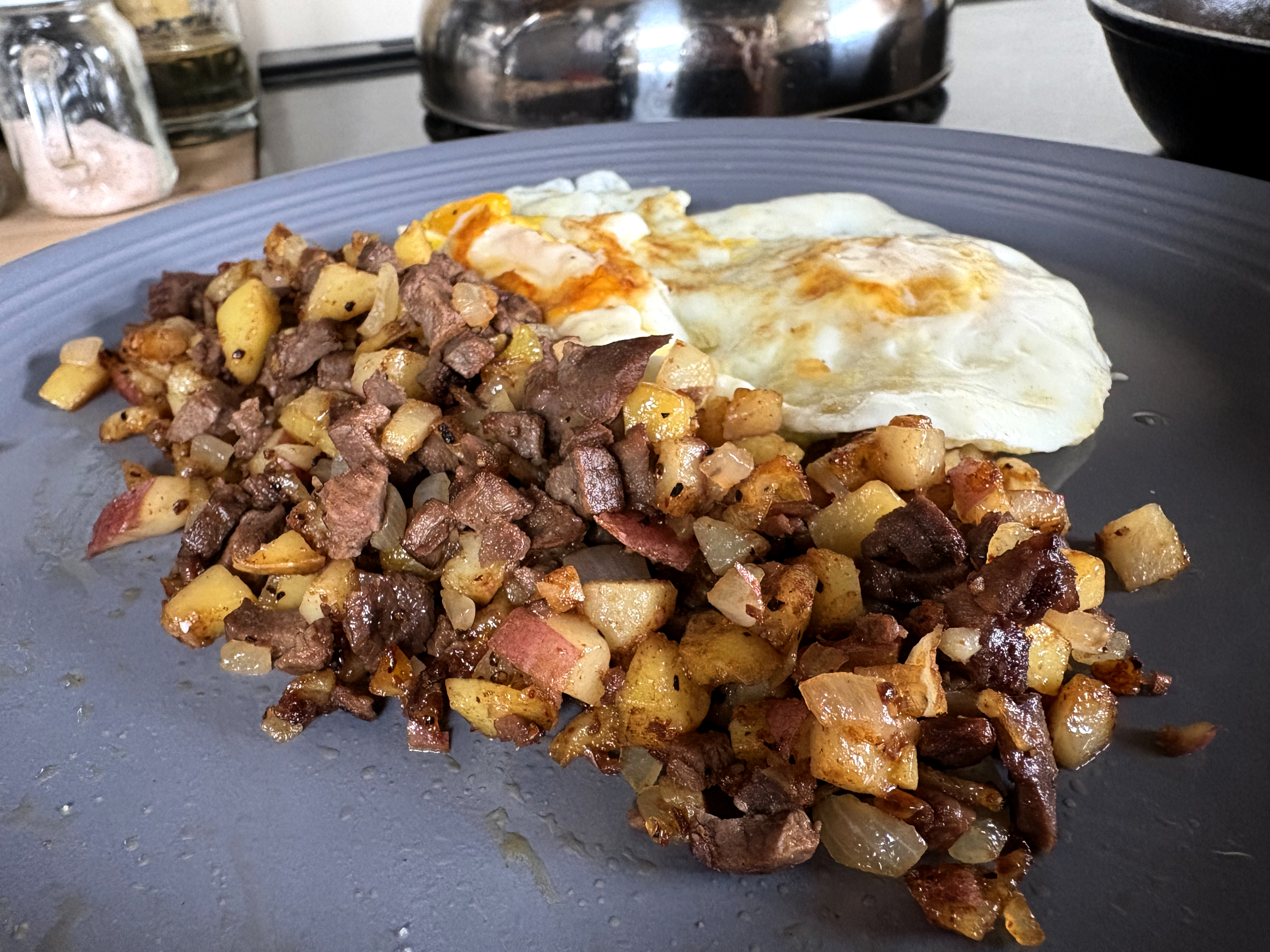 Venison breakfast hash served with fried eggs on a plate