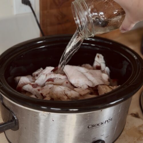 pouring water over deer fat in a crockpot