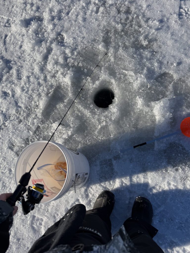 fishing through a hole one a frozen lake